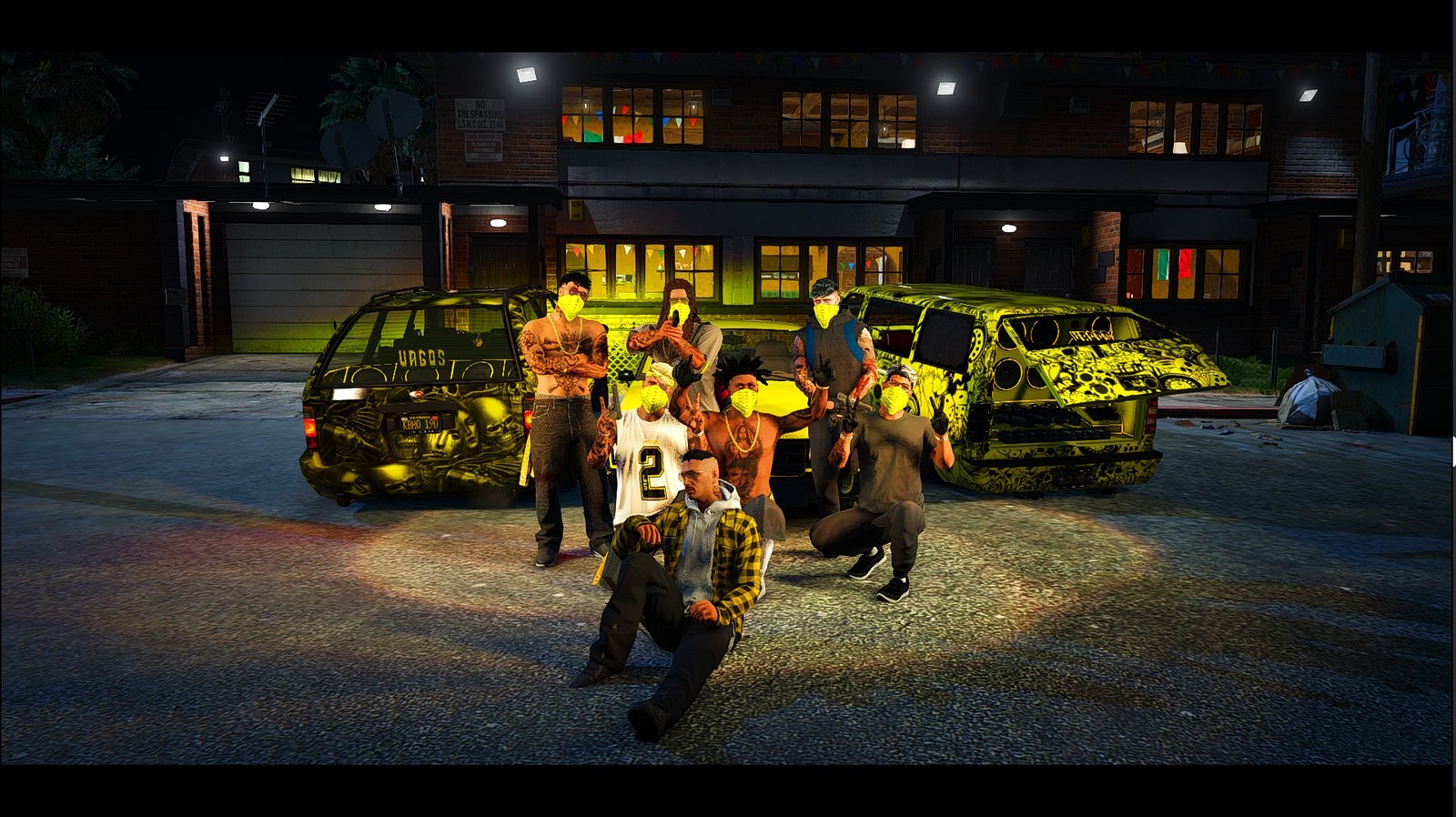 A Los Santos Vagos tagjai sárga kendőkben, a banda autói előtt